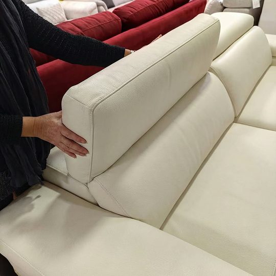 Manos inclinando el cabezal del sofá Uniq
