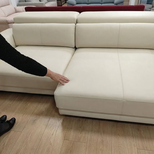 Manos deslizando el asiento del sofá Uniq hacia delante